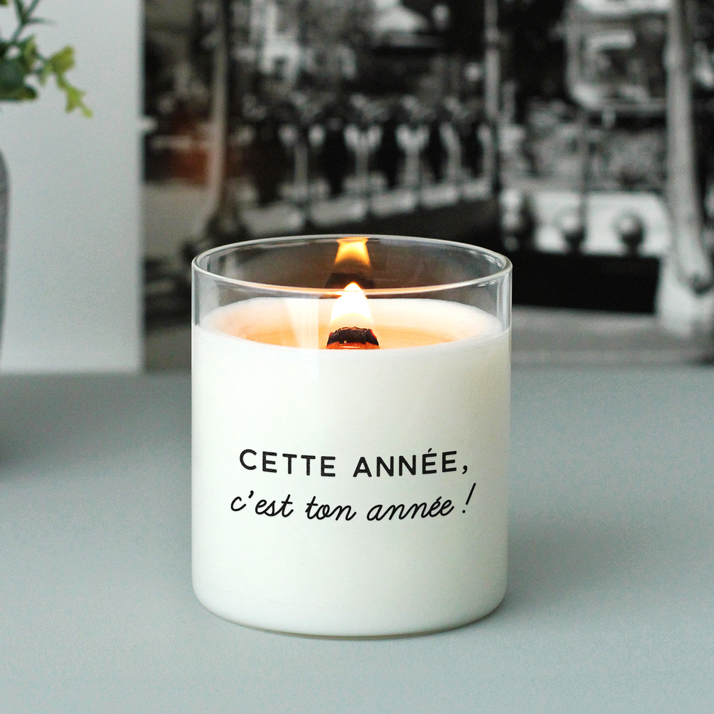 Bougie allumée avec le message "Cette année, c’est ton année", posée sur une surface grise, ambiance sobre et inspirante – idée cadeau de nouvelle année.