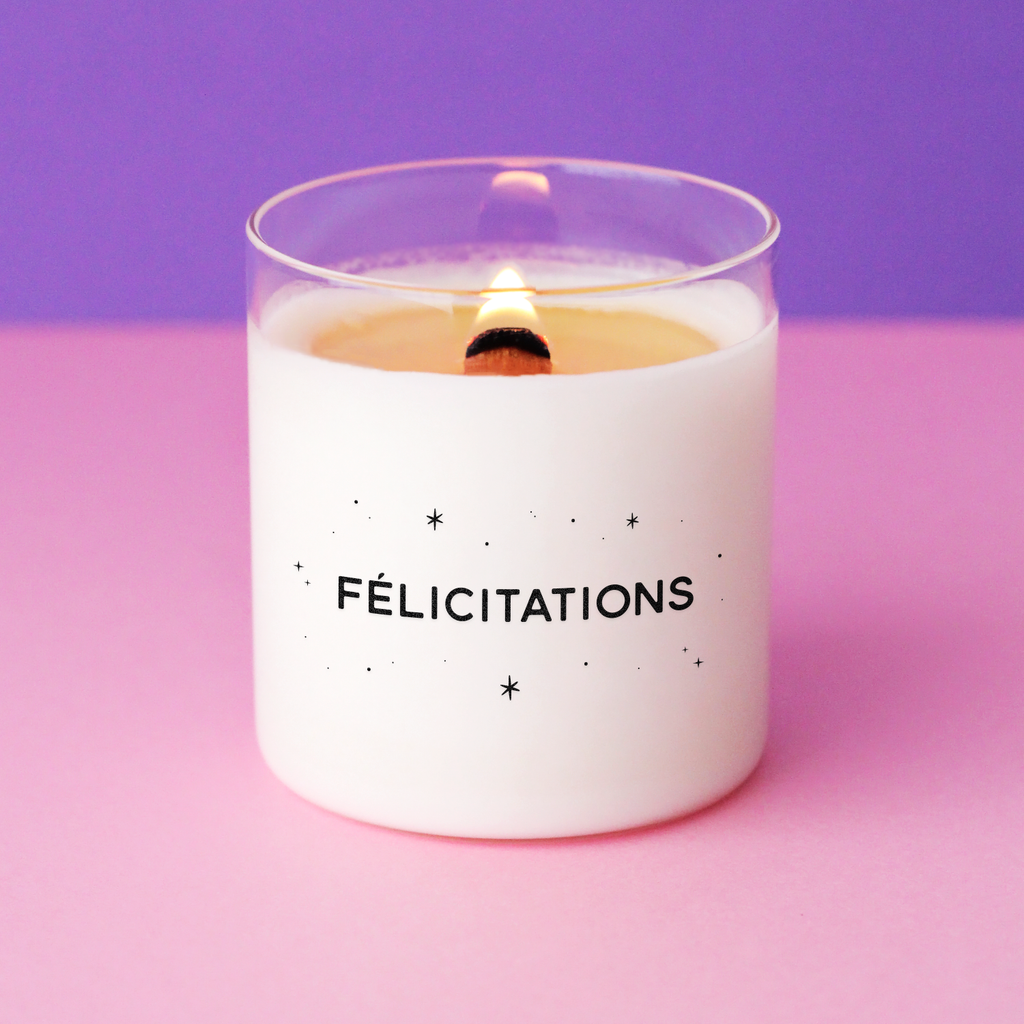 Bougie blanche avec l’inscription « Félicitations » entourée de petites étoiles noires. Idée cadeau élégante pour célébrer une réussite ou une bonne nouvelle.