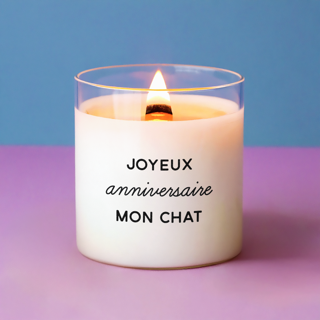 Bougie allumée avec le message "Joyeux anniversaire mon chat", posée sur fond violet et rose, idéale pour un cadeau d’anniversaire original et affectueux.