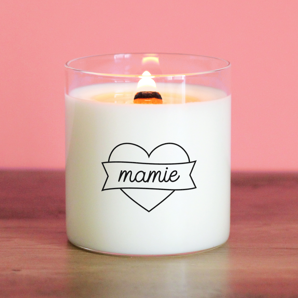 Bougie blanche avec un cœur noir et le mot « mamie » inscrit au centre d’une bannière. Idée cadeau douce et affectueuse pour une grand-mère.