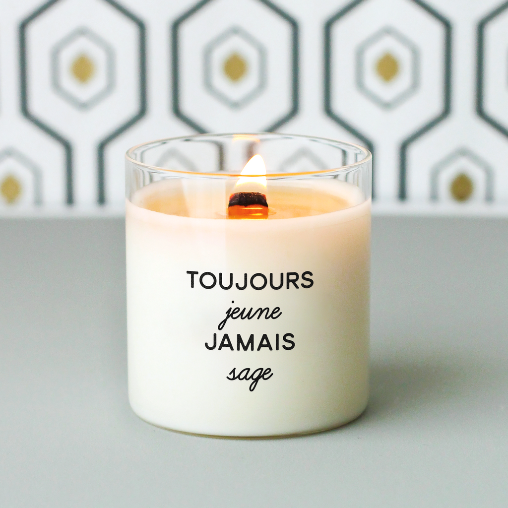 Bougie à message « Toujours jeune, jamais sage » imprimée sur cire blanche dans un contenant en verre. Cadeau d’anniversaire fun et affirmé pour femme ou ami·e plein·e de vie.